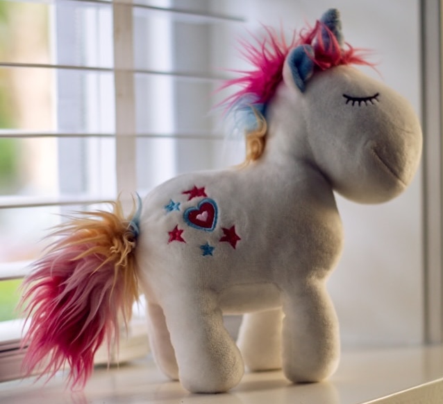 Smug and content looking unicorn stuffed toy side view. Perhaps she knows to choose happiness over success.